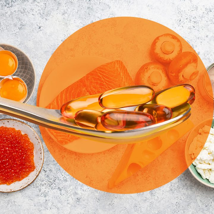 Alimentos saludables como pescado y huevo servidos en una mesa. Encima, aparece una cuchara conteniendo unas píldoras.