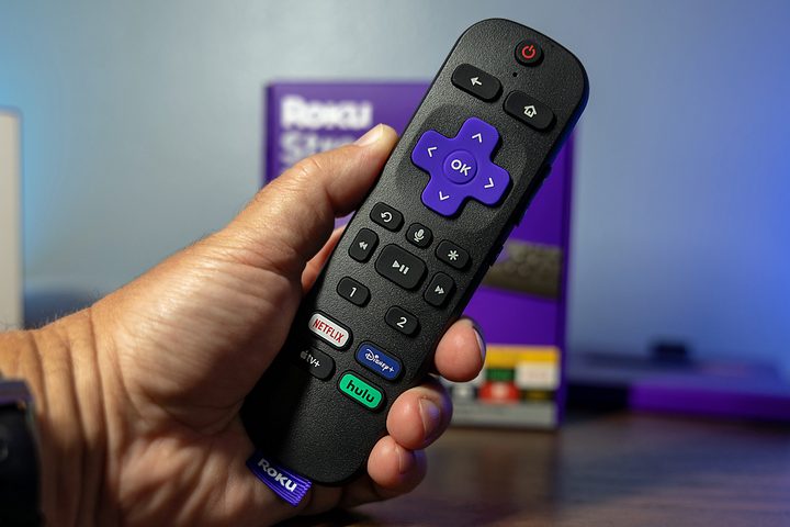 Una mano sostiene el control remoto de un dispositivo Roku.