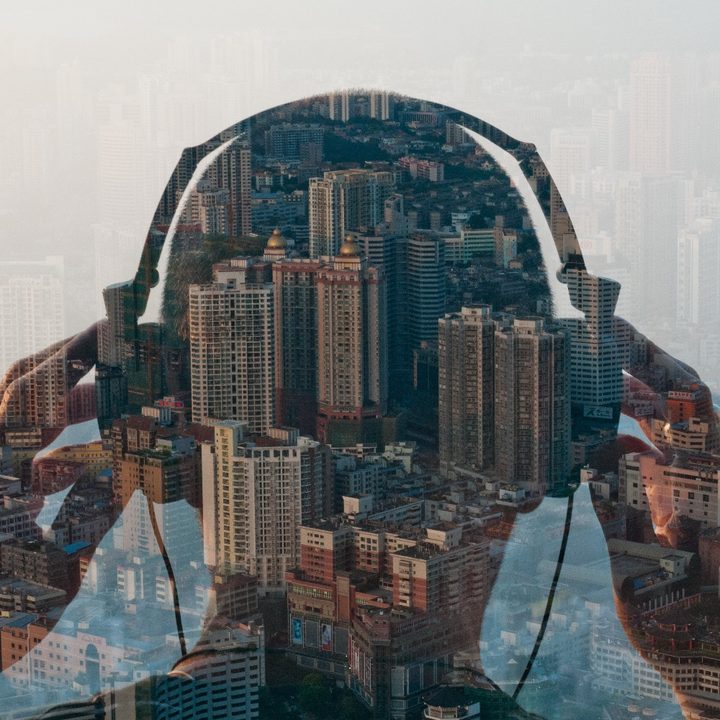 El reflejo en una ventana de una persona que está escuchando música con auriculares