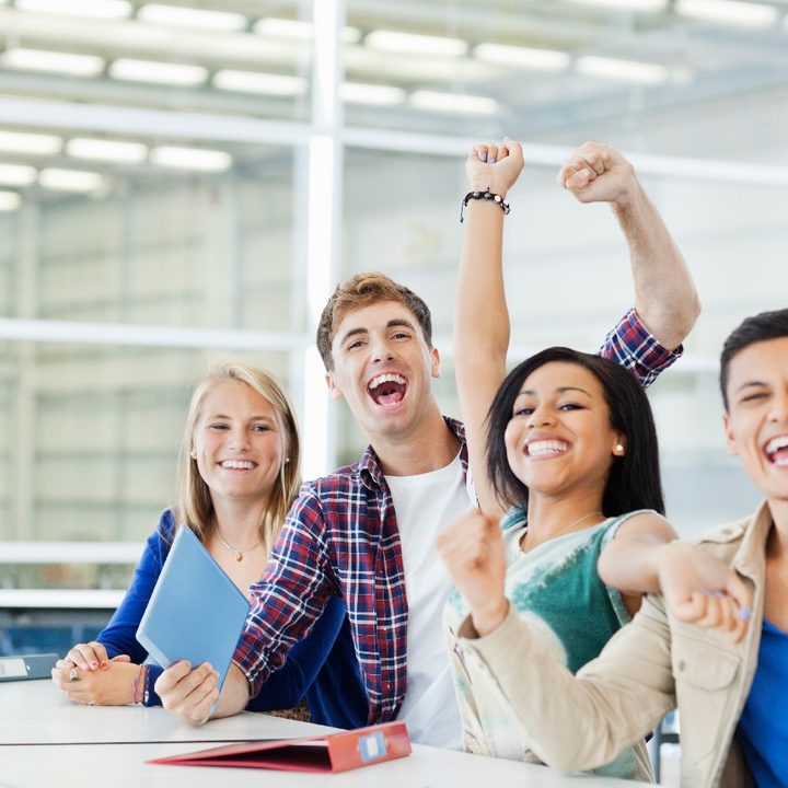 Cuatro estudiantes hacen gestos de victoria