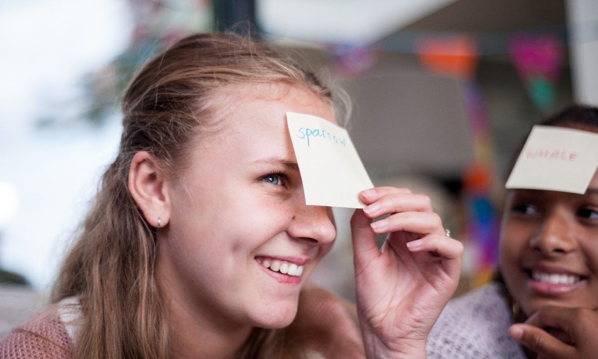 Una mujer se saca una etiqueta con un nombre de su frente