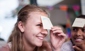 Una mujer se saca una etiqueta con un nombre de su frente