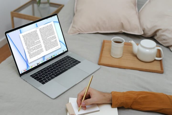 Una persona en la cama con la aplicación de Apple Books abierta en una MacBook.