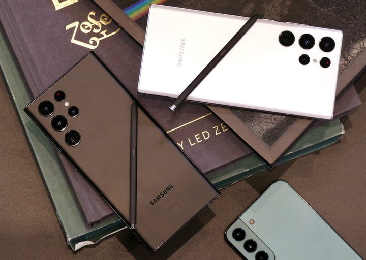 Dos teléfonos Galaxy S22 Ultra en blanco y negro sobre unos libros y un iPhone 13 Pro Max a un lado.