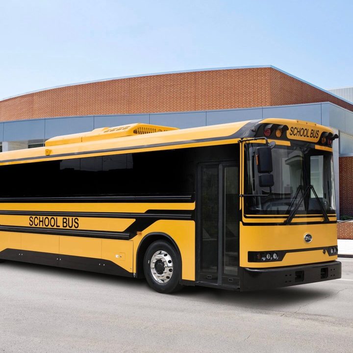 Vista frontal de dos cuartos del autobús escolar eléctrico Tipo D en una calle.