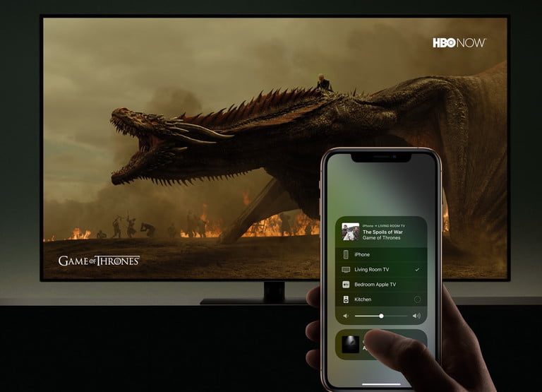 Una persona con un iPhone para transmitir en un televisor Samsung atraves de AirPlay 2.