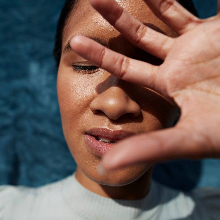 Persona se cubre el sol con la mano