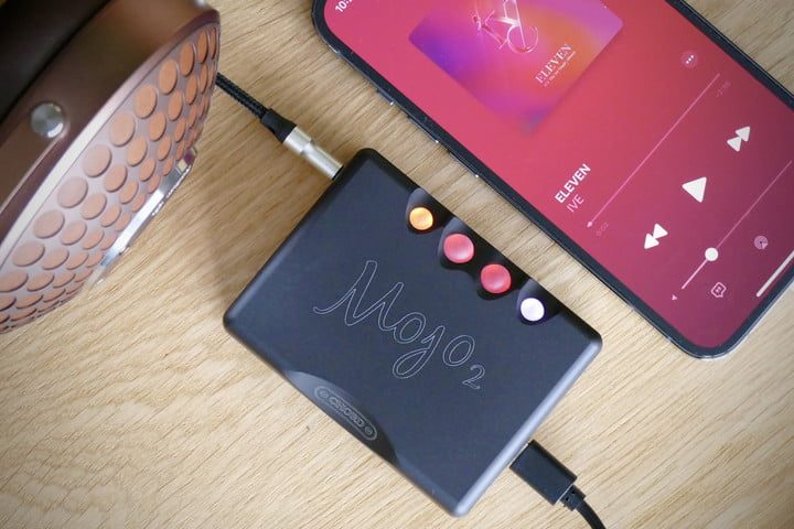 Chord Mojo 2 junto a un celular y conectado a dos cables.