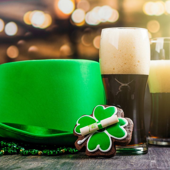Dos vasos de cerveza junto a mercancía relacionada con el Día de San Patricio.