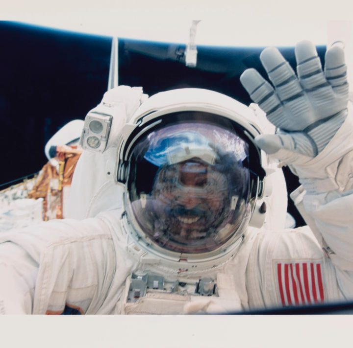 Un astronauta saluda a la cámara durante una caminata en el espacio.