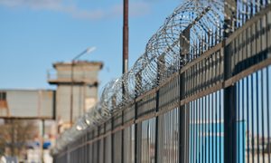Una reja de seguridad rodeando un recinto penitenciario.