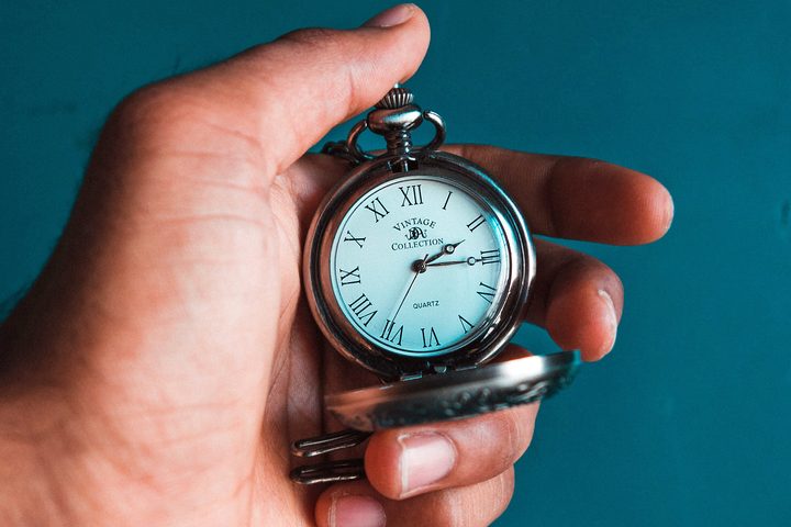 Una mano sostiene un reloj de bolsillo.