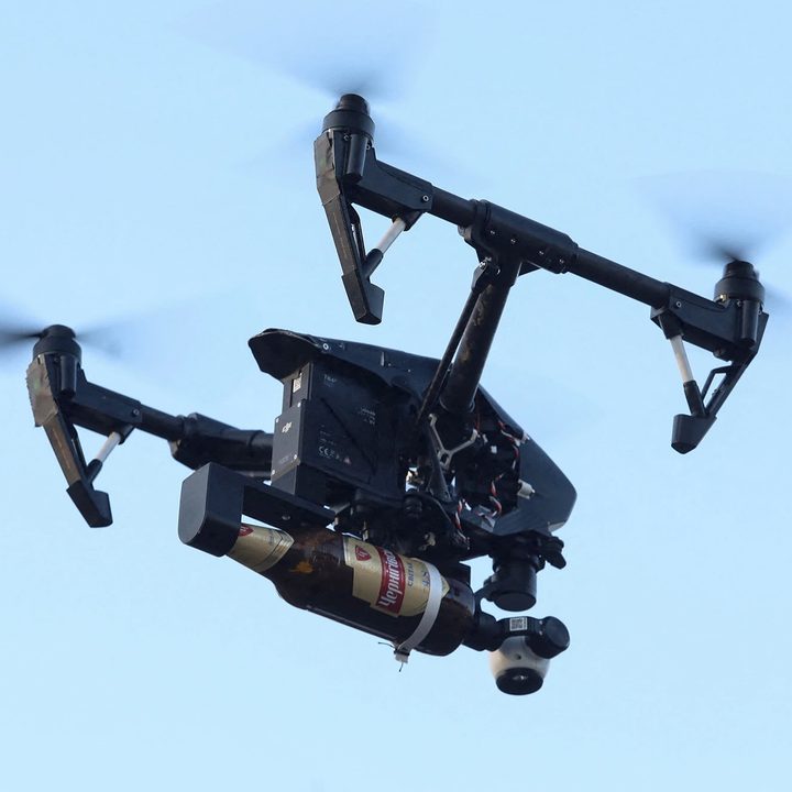 un dron vuela con una bomba molotov adosado en sus brazos