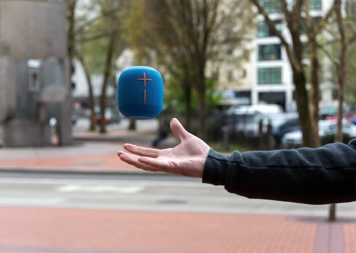 Una bocina Ultimate Ears Wonderboom 2 lanzada por la mano de un hombre hacia arriba.