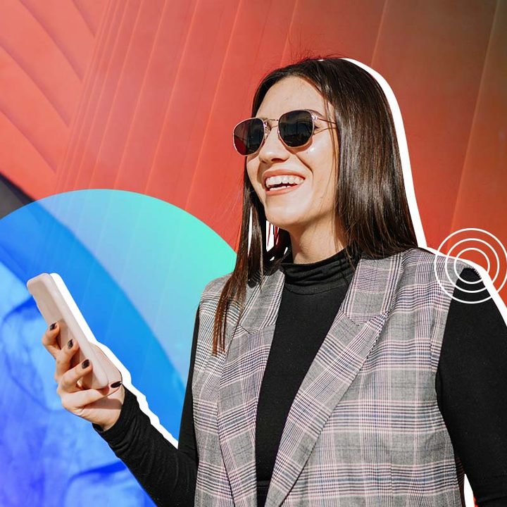 Una mujer sosteniendo un celular enorme en la mano.