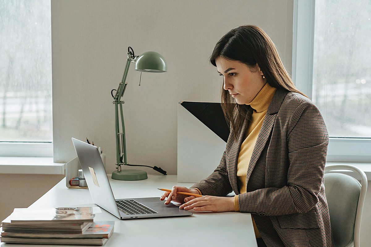 Una mujer trabaja en una laptop en una oficina.