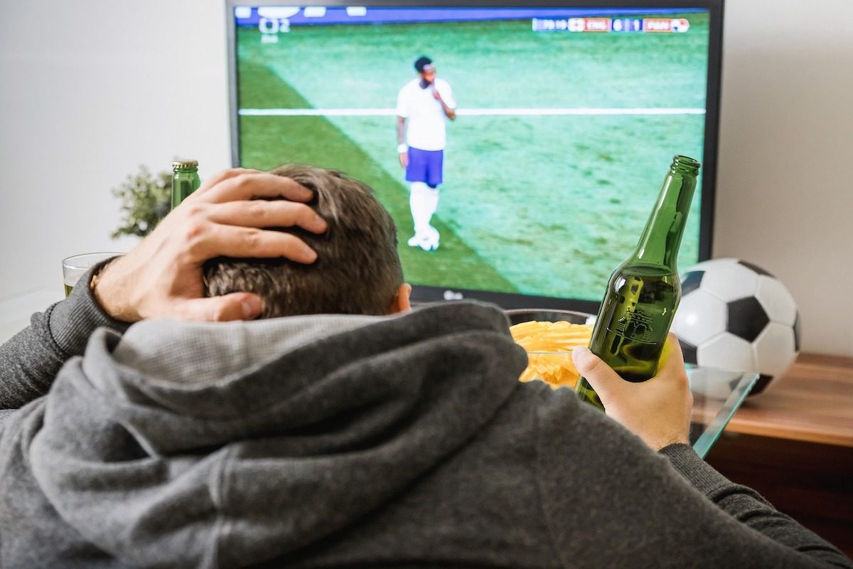 Un hombre viendo f&uacute;tbol en la TV.