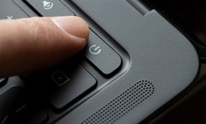 Persona pulsando la tecla de encendido en una Chromebook.