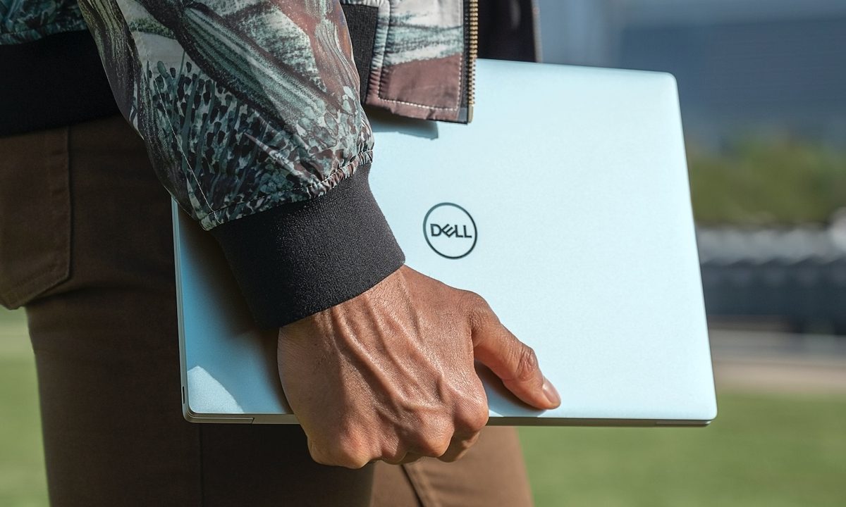 Persona llevando una laptopp Dell.