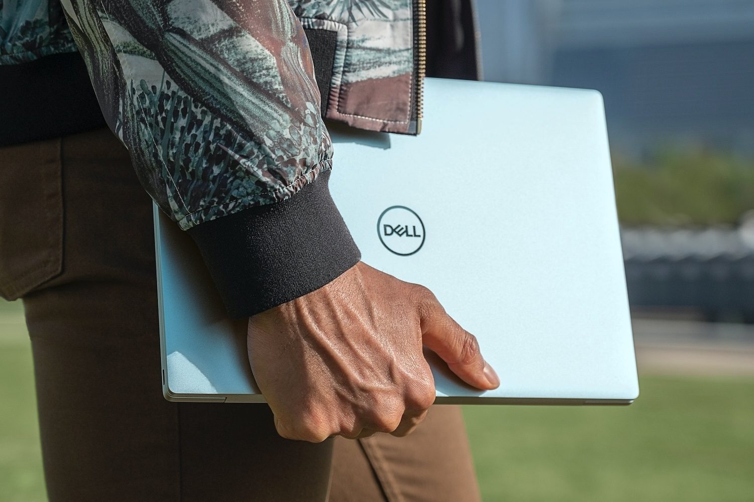 Persona llevando una laptopp Dell.