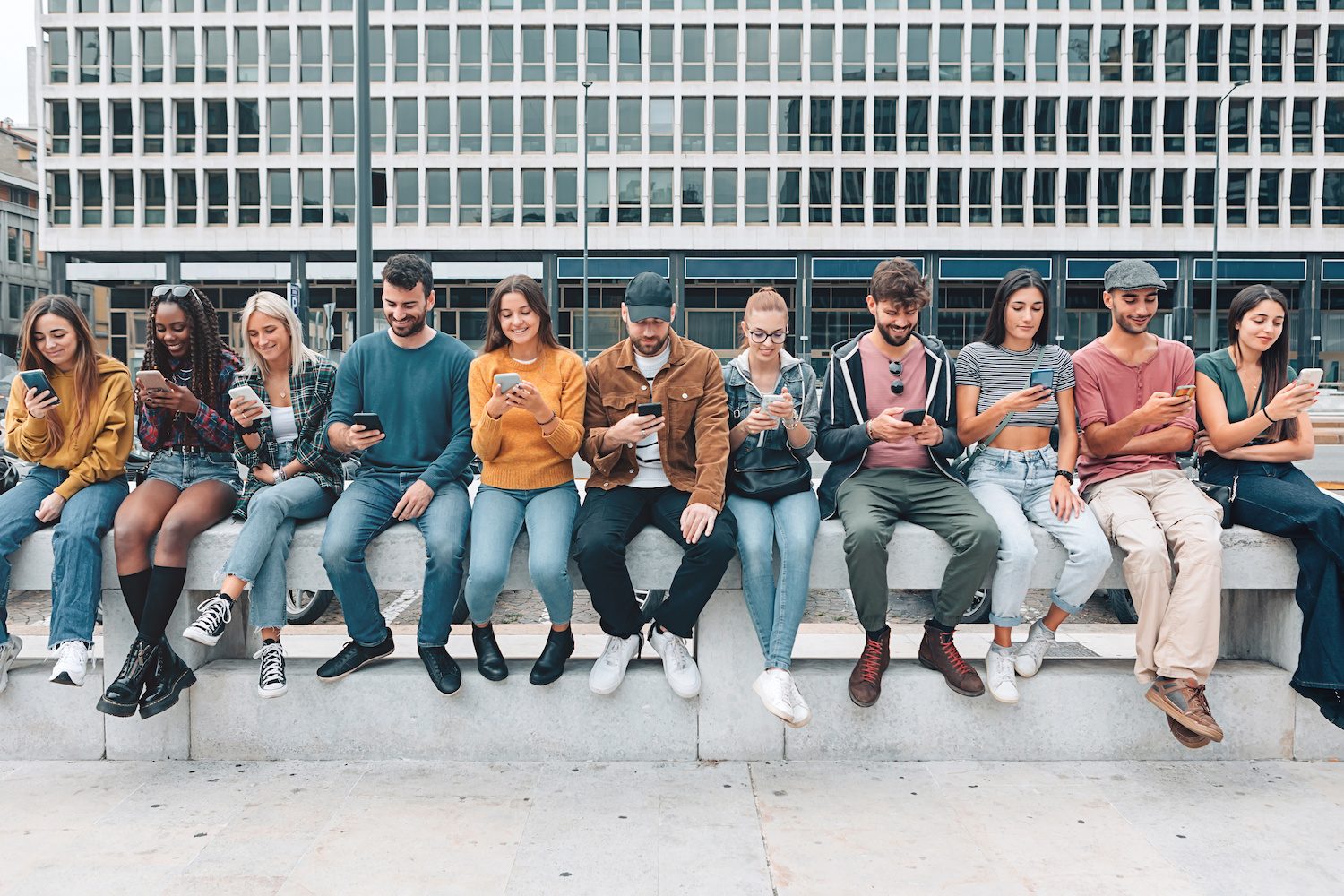 Un grupo de personas mirando sus teléfonos celulares.
