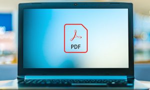Pantalla de laptop con logo de PDF– Cómo combinar archivos PDF de forma fácil, rápida y segura