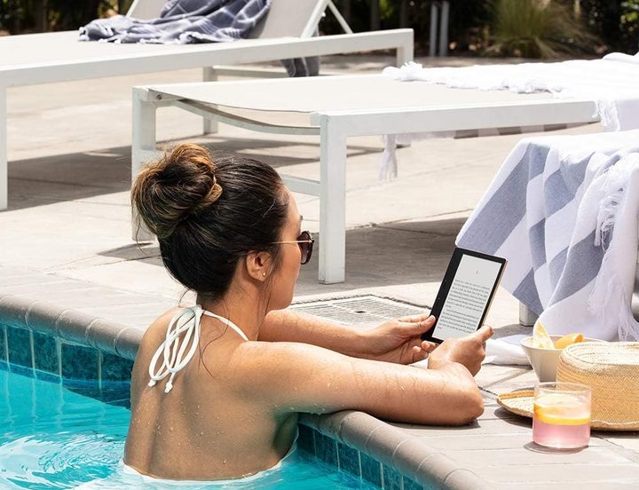 Mujer lee en Kindle en una piscina