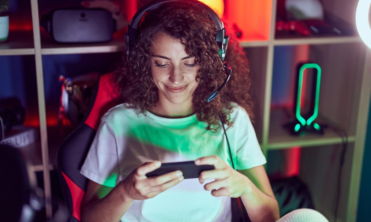 mejores emuladores psp android joven hermosa mujer hispana streamer jugando videojuegos usando telefono inteligente sala jueg