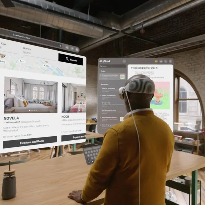 Un hombre que lleva Vision Pro usando un teclado flotante mientras mira pantallas virtuales.