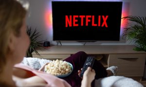 Una persona viendo Netflix en su televisor comiendo palomitas de maíz.