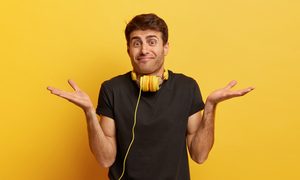 Un hombre confundido usando audífonos.