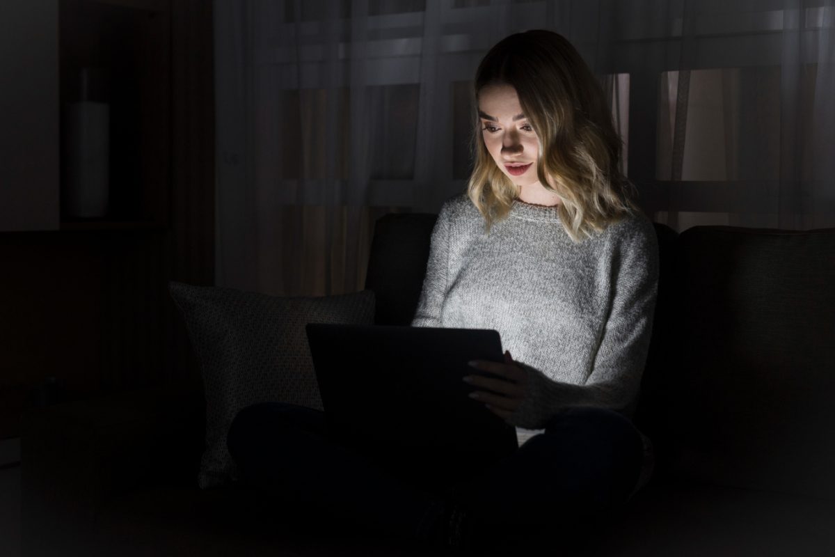 Mujer trabajando en una laptop a oscuras en un apagón