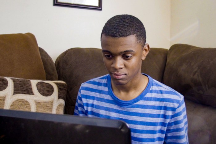 un chico usando y mirando una computadora