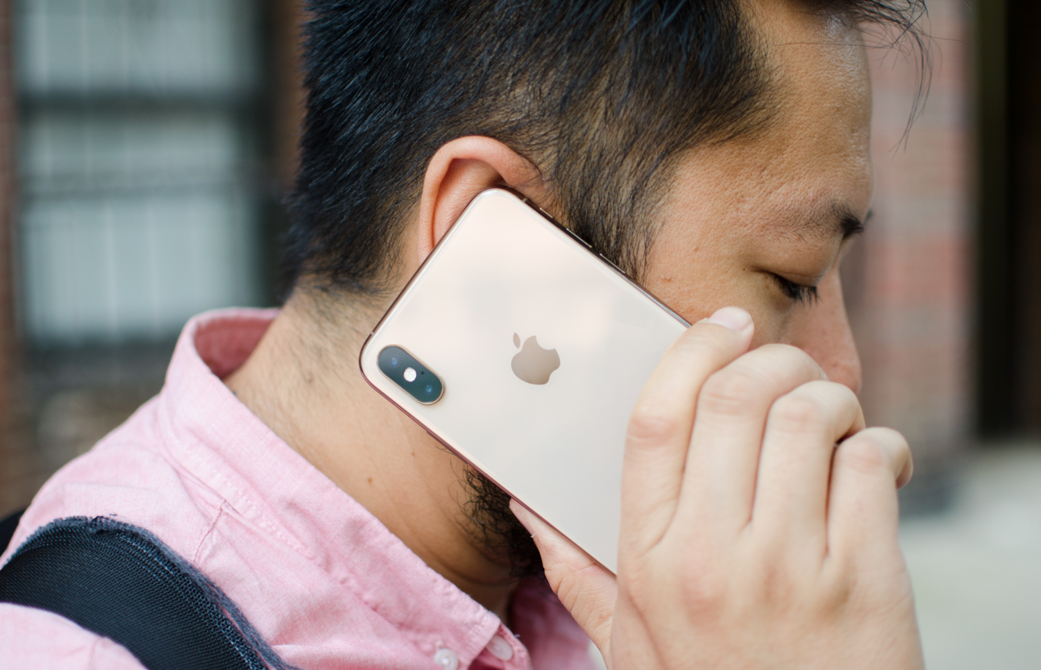 el rostro de una persona de lado sosteniendo un teléfono con su mano en su oreja