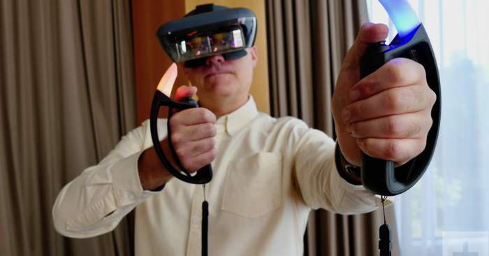 Un hombre con lentes de realidad virtual usando una de las mejores laptops para VR