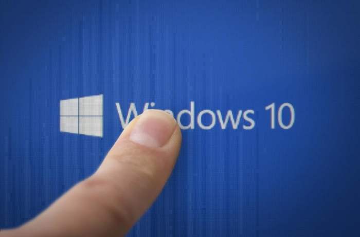 Una persona apunta con su dedo el logo de Windows 10