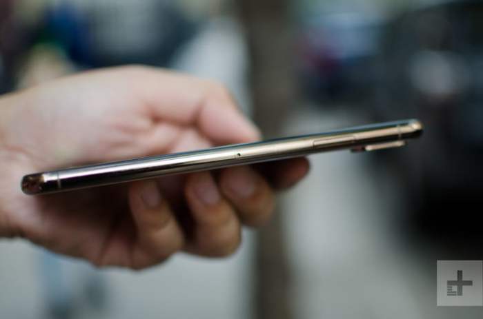 Vista lateral de un iPhone XS Max, mientras es sostenido por una persona.
