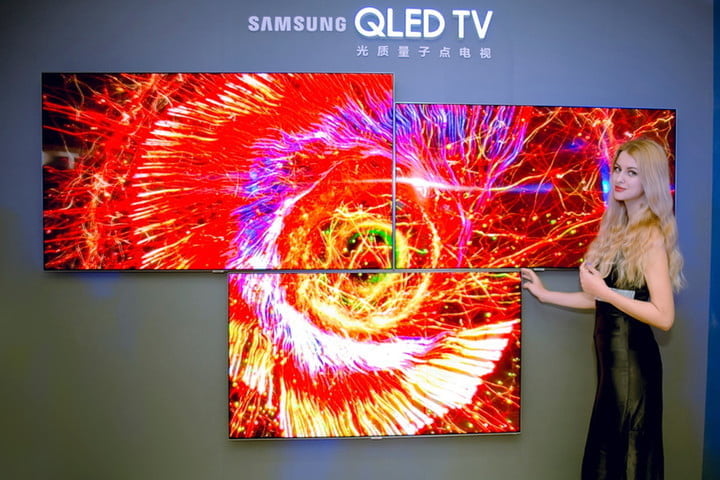 Una mujer muestra un televisor Samsung QLED