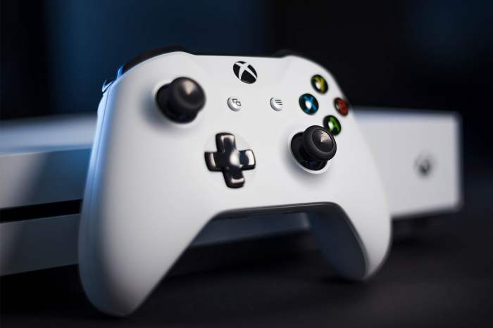 Control de Xbox blanco al frente de una consola para aprender cómo jugar Xbox One en computadora Windows 10