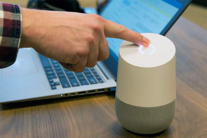 Una persona toca con su dedo índice un dispositivo para mostrarnos cómo hacer llamadas con Google Home