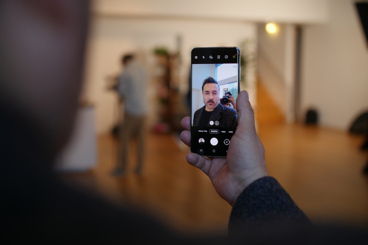 homre mirando la pantalla de un Galaxy S20 con cámara selfie abierta