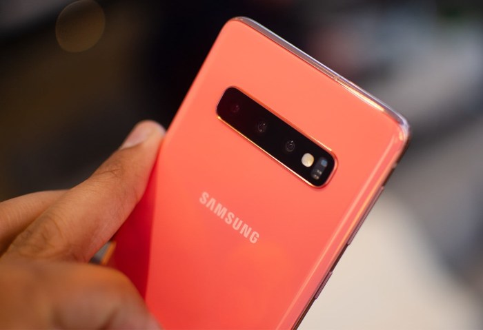 Una persona manipula un teléfono Galaxy S10 de color rojo.
