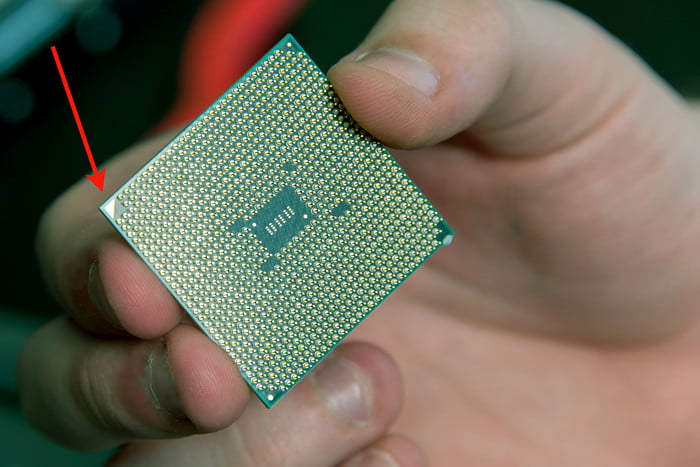 procesador AMD sostenido en la mao de un hombre mostrando los pines