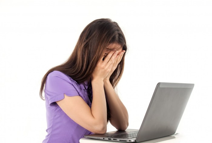 Mujer estresada frente a su computadora.