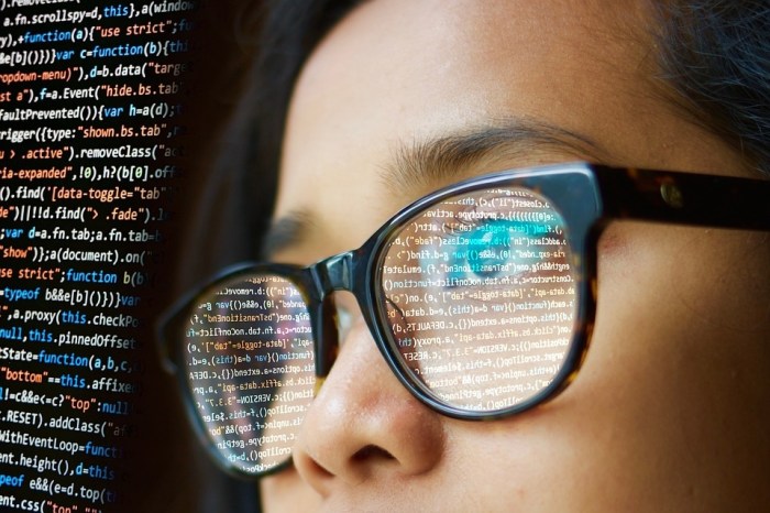 Una mujer con anteojos revisa códigos de programación