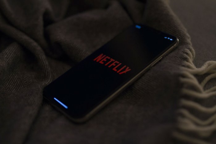Un teléfono con el logo de Netflix sobre una cama