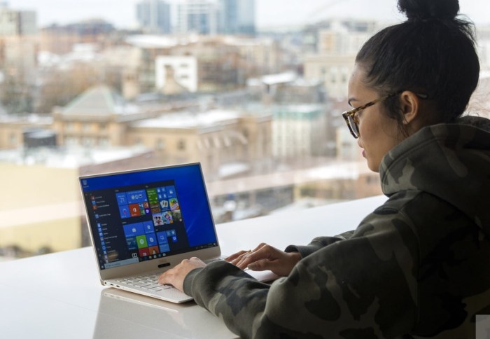 Una mujer usando su laptop para aprender a usar todas las funciones del Explorador de Archivos en Windows 10