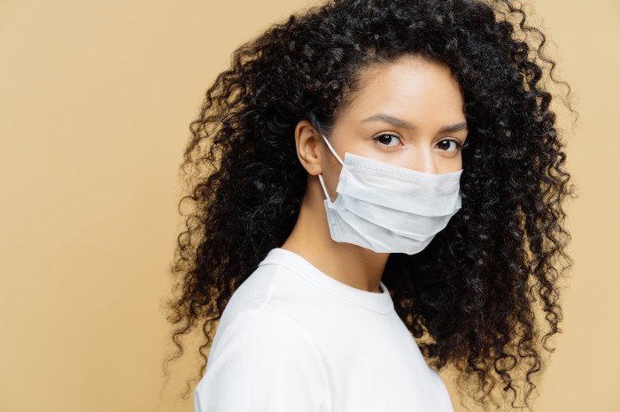 mascarilla john hopkins woman with curly hair wearing mask against colored background