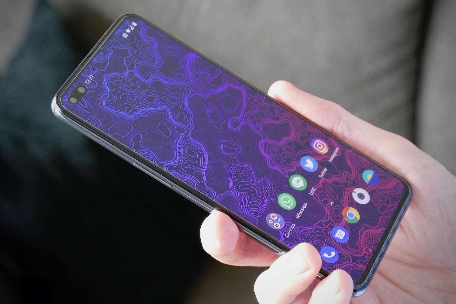 una mano sujeta un teléfono OnePlus Nord con la pantalla encendida en el menú principal