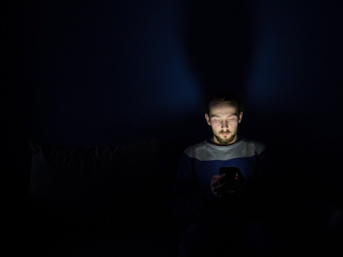 Una persona usa un teléfono en la oscuridad